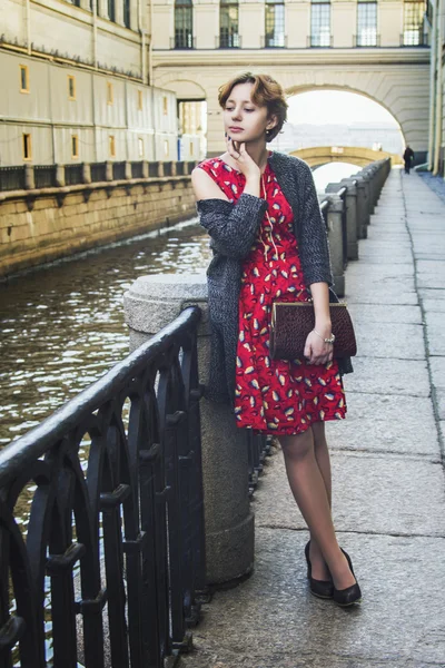Dívka s kudrnatými červené vlasy čeká na mostě — Stock fotografie