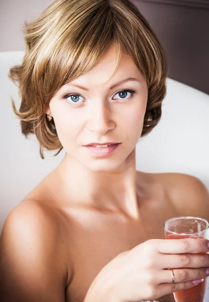Piękna blondynka młoda kobieta kąpiel z lampką szampana — Zdjęcie stockowe