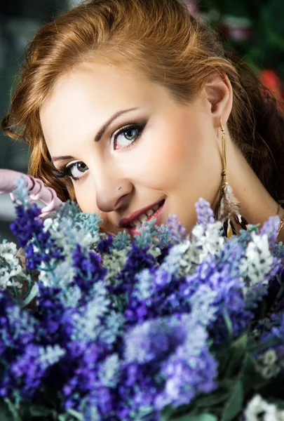 Piękna młoda kobieta z idealny makijaż trzyma kwiaty niebieski — Zdjęcie stockowe