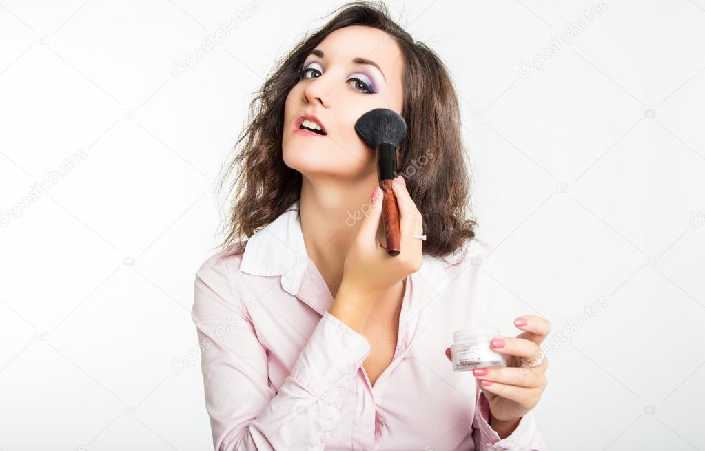 Beautiful girl with powder brush on white background