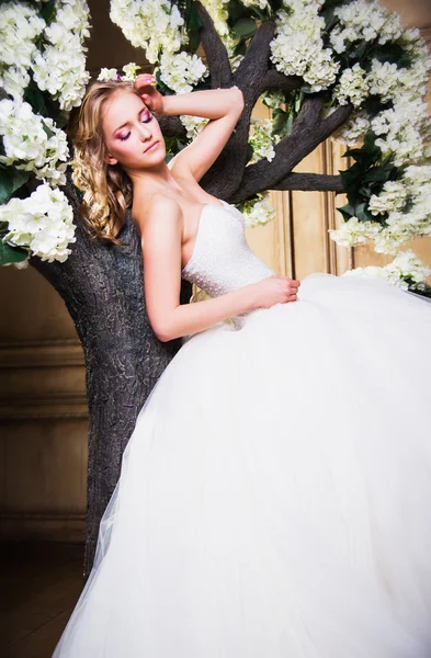 Beautiful blonde bride in a luxurious wedding dress in interior — Stock Photo, Image