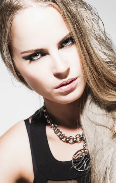 Close-up portret van een jonge vrouw met avond make-up, lang blond haar en sterke blik — Stockfoto