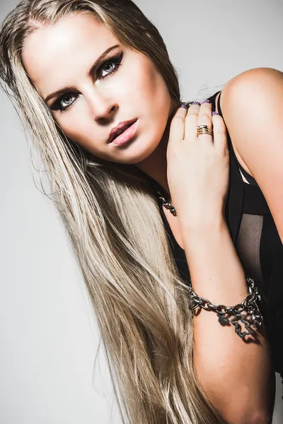 Close-up portrait of young woman with evening make-up, long blonde hair and strong look — Stock Photo, Image