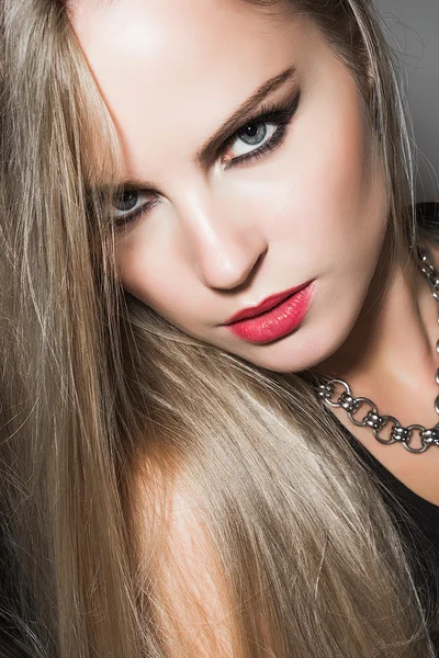 Close-up portrait of young woman with evening make-up, long blonde hair and strong look — Stock Photo, Image