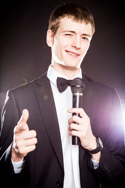 Szép elegáns fiatalember mikrofonnal közeli portréja — Stock Fotó