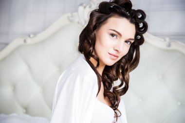 Yatak odasında bir sabah beyaz ipek iç çamaşırı içinde güzel bir gelin