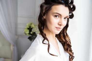 Yatak odasında bir sabah penceresinde yakınındaki beyaz ipek iç çamaşırı içinde güzel bir gelin