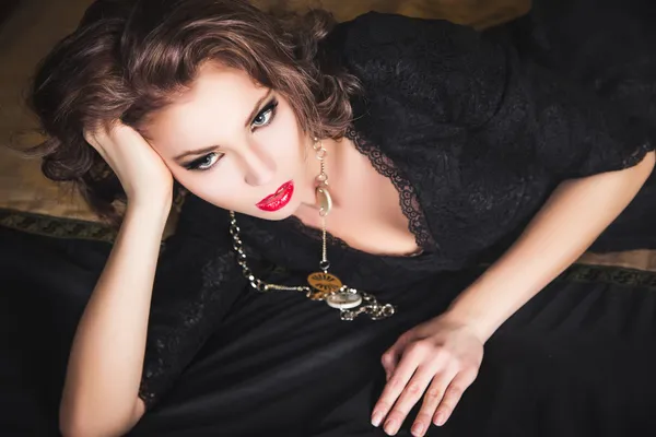 Yakın çekim yatak üzerinde poz siyah elbiseli seksi koyu saçlı kız portresi — Stok fotoğraf