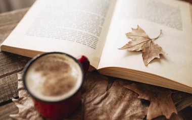 Milyon kakao ve tarçınlı kahve. Sonbaharda kitap okuyorum. Sonbahar yapraklı ahşap masa. Sabah rutini... yapraklara odaklan.