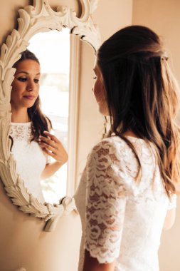 Düğünden önce kuşkucu gelin kendine bakıyor ve gergin bir şekilde aynada saçını tarıyor. Önemli bir gün. Düğün ve evlilik kavramı.