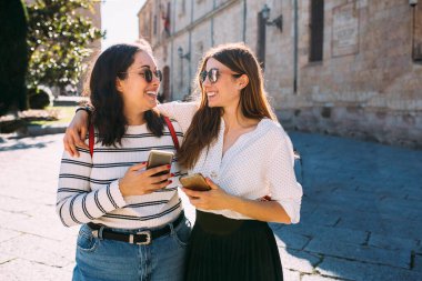 İspanya, Salamanca 'da antik bir şehirde cep telefonuyla konuşan iki kız arkadaş..