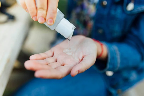 Woman hands using wash hand sanitizer hydroalcoholic gel dispenser, against coronavirus or Covid-19 virus and other viruses. Sanitize. Focus on hand