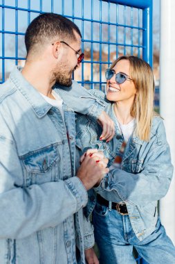 Kız arkadaşı ve erkek arkadaşı çitleri sıkıca tutuyor birbirlerine bakıyor ve ellerine dokunuyorlar. Mutlu çift.