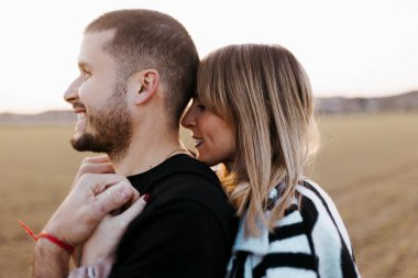 Kucaklaşan ve kırsal kesimde kameraya bakan çiftler kucaklaştılar. Sevgili ve sevgili.