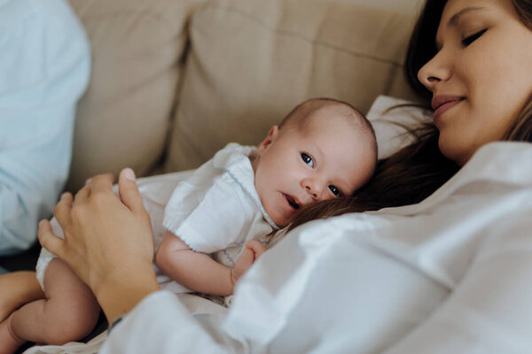 Newborn Baby Boy Looking Camera Top His Mother Lying Sofa Stock Image