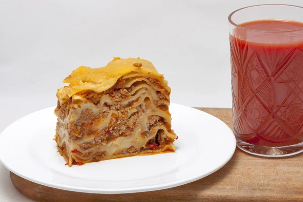 Lasagna and a glass of tomato juice — Stock Photo, Image