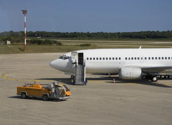 Avião estacionado no aeroporto — Fotografia de Stock