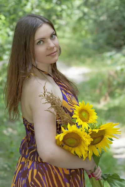 Pretty green eyes woman with sunflowers — Stock Photo, Image