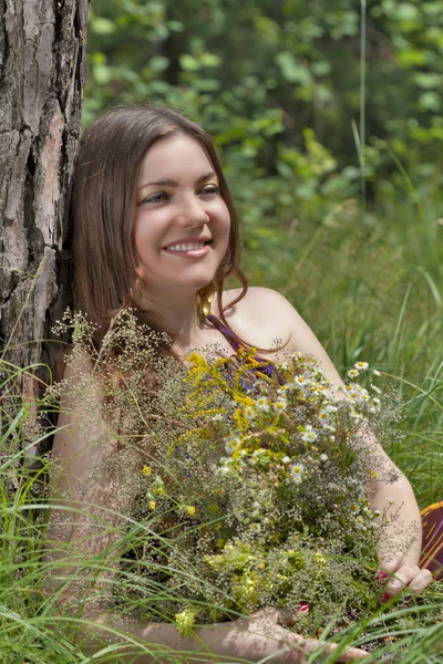 Szép nő, a vadon élő virágok csokor — Stock Fotó