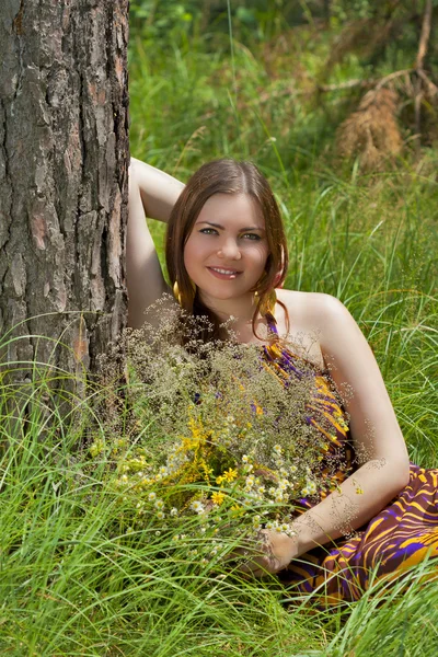 Pretty woman with bouquet of wild flowers — Stock Photo, Image