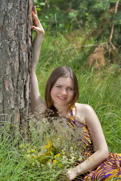 Pretty woman with bouquet of wild flowers — Stock Photo, Image