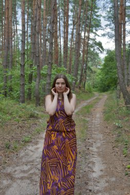 orman yolu üzerinde duran genç ve güzel kadın