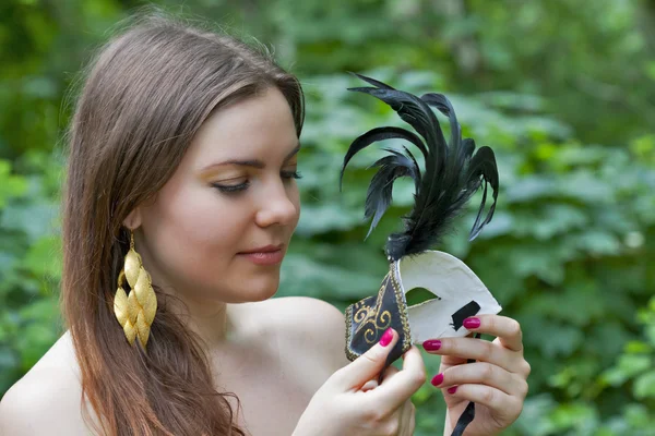 Jonge vrouw op zoek op Venetiaanse carnaval masker — Stockfoto