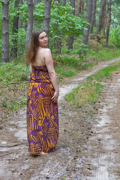 Pretty young woman standing on the forest road — Stock Photo, Image