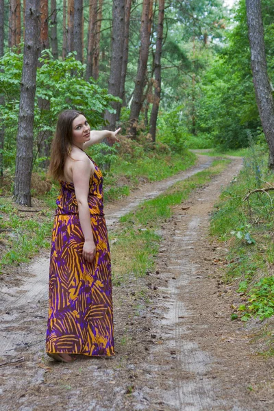 Pretty young woman standing on the forest road — Stock Photo, Image