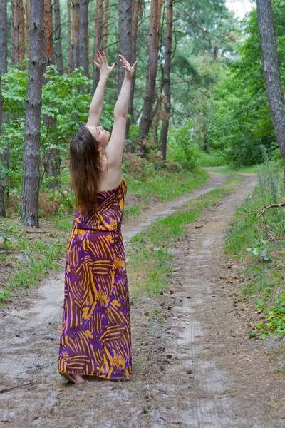 Mujer joven y bonita de pie en el camino del bosque — Foto de Stock