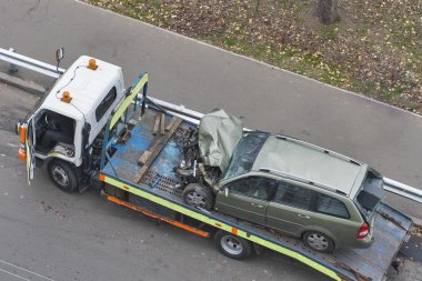 Car after road accident shipped to tow truck clipart