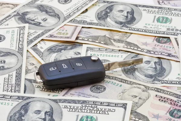Chaves do carro sobre notas de dólar — Fotografia de Stock