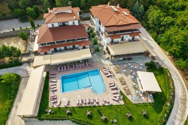 Açık havuzu ve barı olan bir otel kompleksi üzerinde hava aracı görüntüsü. Larissa, Yunanistan.