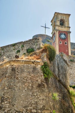 Ünlü turistik tarihi eser saat kulesiyle Eski Venedik Kalesi ve tepenin üstünde haç. Kerkyra Şehri, Korfu, Yunanistan
