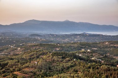 Yunanistan 'ın Korfu adasının merkez ve batı sahillerinde dramatik gün batımı manzarası.