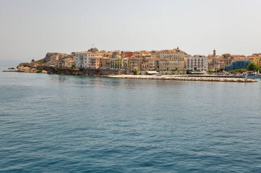 Kerkyra şehir manzarası. Korfu adası, Yunanistan. Sakin turkuaz suyu ve renkli eski evleri olan deniz koyuna..