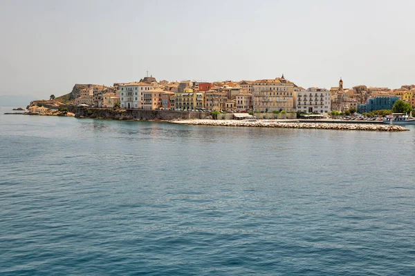 Kerkyra şehir manzarası. Korfu adası, Yunanistan. Sakin turkuaz suyu ve renkli eski evleri olan deniz koyuna..