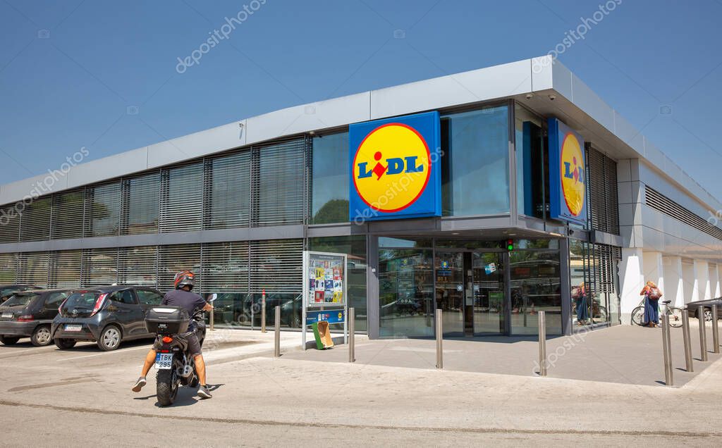 Corfu, Greece - July 31, 2021: People visit Lidl supermarket with parking lot. Lidl is a German discount supermarket chain that operates over 7200 stores worldwide, it was founded in 1930