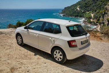Glyfada, Korfu, Yunanistan - 06 Ağustos 2021: Beyaz Skoda Fabia dağlarda deniz kıyısına park etti. 1999 yılından beri Çek otomobil üreticisi Skoda Auto tarafından üretilen bir mini otomobildir..