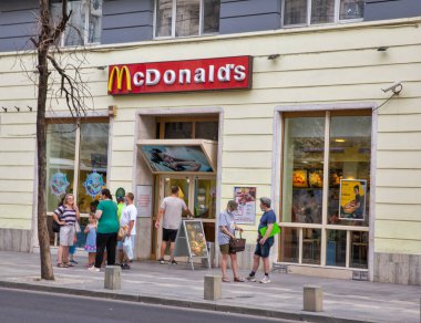 Bükreş, Romanya - 12 Ağustos 2021: İnsanlar şehir merkezindeki McDonald 's restoranını ziyaret ediyor. 1940 yılında Richard ve Maurice McDonald tarafından işletilen bir restoran olarak kurulan bir Amerikan fast food şirketidir..