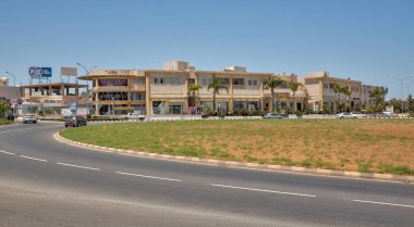 Paralimni, Kıbrıs - 26 Mayıs 2021: Çeşitli dükkanlarla dolambaçlı yol. Türkiye 'nin 1974' teki işgalinden bu yana Paralimni başta mültecilerin göçü nedeniyle boyut ve statüde artış kaydetti..