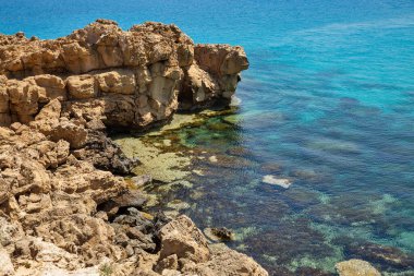 Seascape Cape Greco yarımadası parkı, Kıbrıs. Ulusal parkı, kaya yolları, turkuaz bir gölü ve doğal bir taş köprüsü olan dağlık bir yarımadadır..