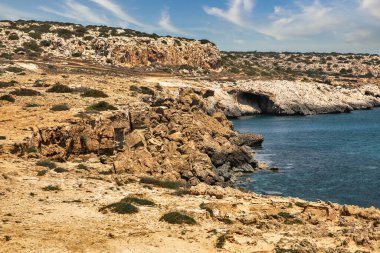 Seascape Cape Greco yarımadası parkı, Kıbrıs. Ulusal parkı, kaya yolları, turkuaz bir gölü ve doğal bir taş köprüsü olan dağlık bir yarımadadır..