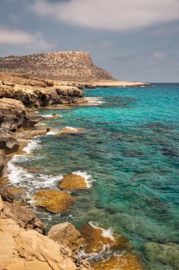 Seascape Cape Greco yarımadası parkı, Kıbrıs. Ulusal parkı, kaya yolları, turkuaz bir gölü ve doğal bir taş köprüsü olan dağlık bir yarımadadır..