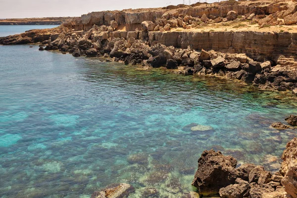 Seascape Cape Greco yarımadası parkı, Kıbrıs. Ulusal parkı, kaya yolları, turkuaz bir gölü ve doğal bir taş köprüsü olan dağlık bir yarımadadır..