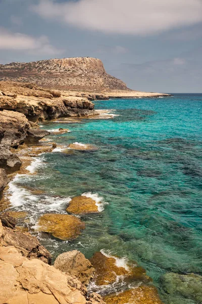 Seascape Cape Greco yarımadası parkı, Kıbrıs. Ulusal parkı, kaya yolları, turkuaz bir gölü ve doğal bir taş köprüsü olan dağlık bir yarımadadır..
