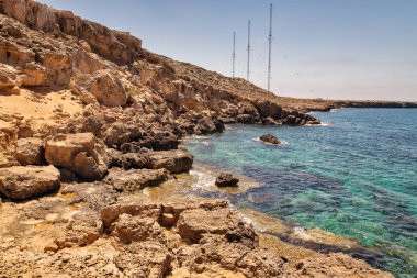 Kıbrıs 'taki İngiliz askeri üssünün radar istasyonuyla Cape Greco yarımadasına giden peyzaj yolu. Ulusal parkı, kaya yolları ve turkuaz lagünü olan dağlık bir yarımadadır..