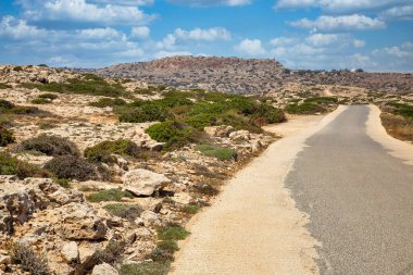 Kıbrıs, Cape Greco yarımadasına giden peyzaj yolu. Ulusal parkı, kaya yolları, turkuaz bir gölü ve doğal bir taş köprüsü olan dağlık bir yarımadadır..