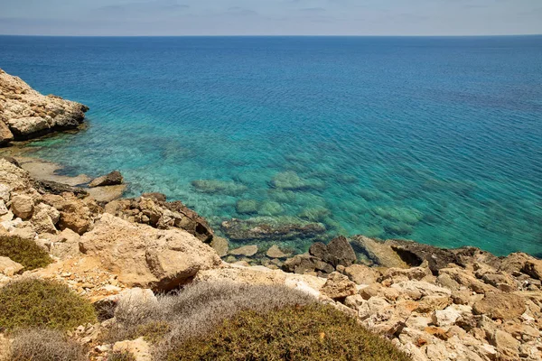 Seascape Cape Greco yarımadası parkı, Kıbrıs. Ulusal parkı, kaya yolları, turkuaz bir gölü ve doğal bir taş köprüsü olan dağlık bir yarımadadır..