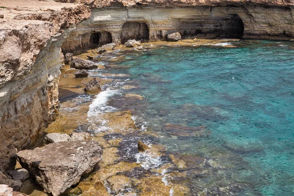 Kıbrıs Rum Kesimi 'nin Ayia Napa kentinde mağaraları olan deniz manzarası. Ulusal parkı, kaya yolları, turkuaz bir gölü ve doğal bir taş köprüsü olan dağlık bir yarımadadır..